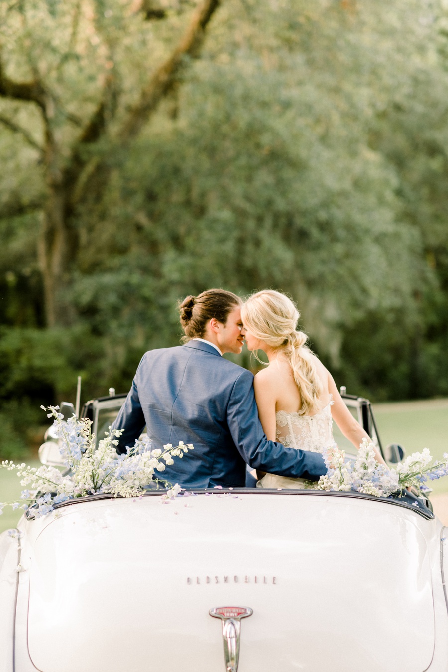RiverOaks Charleston Bride and Groom kissing on back of vintage white car