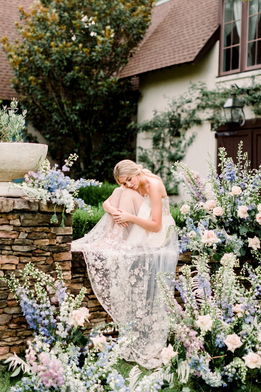 RiverOaks Charleston Bride sitting on ledge with flowers