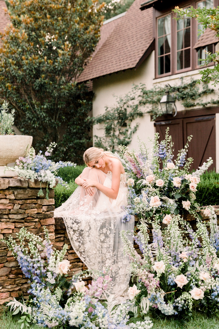 RiverOaks Charleston Bride sitting on ledge surrounded by flowers