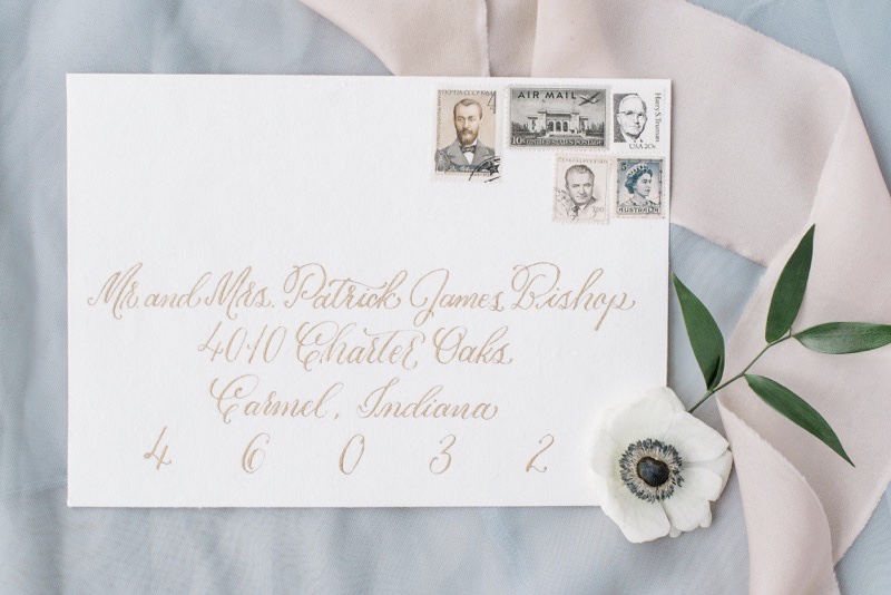 Wedding envelope with gold calligraphy and vintage stamps